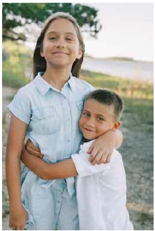 Amelia and Luke Pyszczymuka hugging and smiling in matching light blue outfits