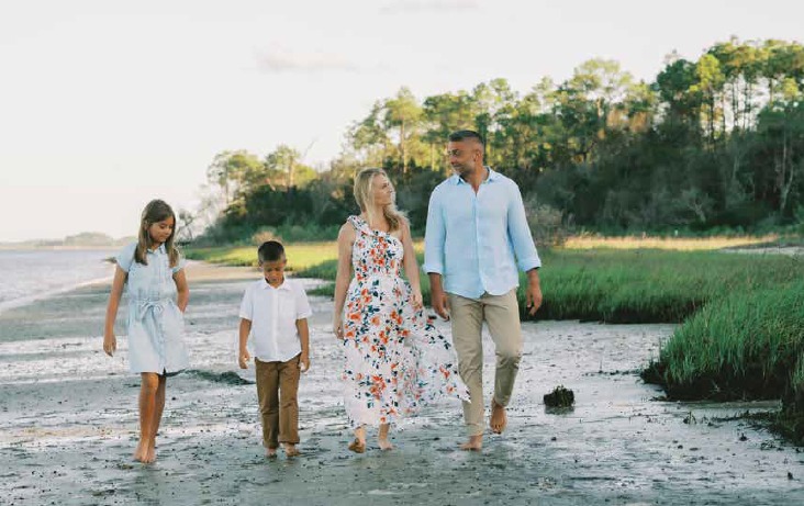 The Pyszczymuka family walking barefoot along the marsh shoreline near Beachwalk